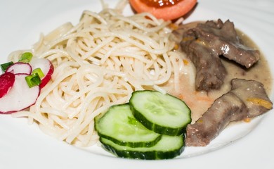 Beef goulash with noodles and fresh vegetables