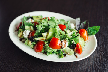 Salad greens and cheese on a white plate