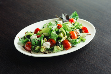 Salad greens and cheese on a white plate