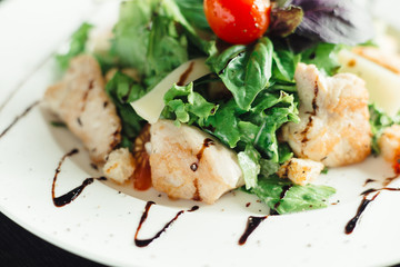 Caesar salad with chicken on white dish