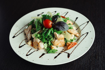 Caesar salad with chicken on white dish