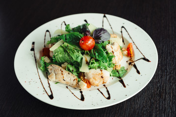 Caesar salad with chicken on white dish