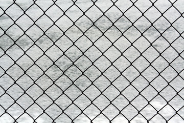 Metal wire mesh fence and snow.