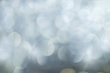 Blurred silver background with bokeh and sparkles.