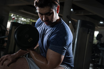 Man lift weight on arm press with studio light shot