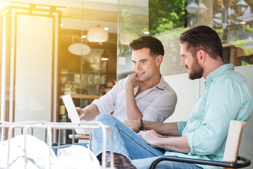 Fototapeta premium Two Westerner Business men working with laptop and smartphone to