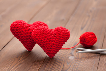 two knitted hearts with wool and knitting needle as symbol for love to knitting