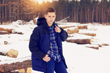 Handsome, stylish and young man correcting his jacket. Early spring, sunny day. Men's fashion.