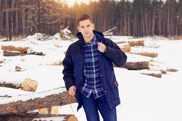 Handsome, stylish and young man correcting his jacket. Early spring, sunny day. Men's fashion.