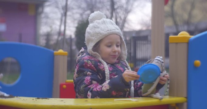 Front View of Small Girl With Toy on the Playground