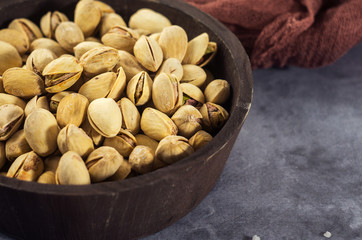 Pistachios in a wooden spoon. Selective focus. Close up