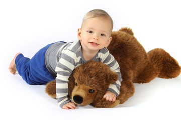 Ein kleiner Junge kuschelt mit einem Plüschbären