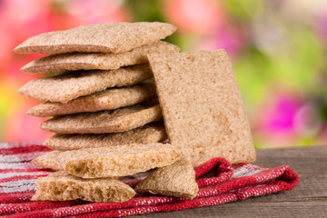 stack of crisp bread on a wooden table with blurred garden background