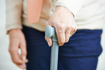 Hand of old woman on cane