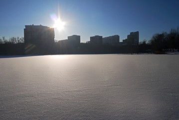 Silhouette of high buildings and the beautiful snowy river. Iset river, Ekaterinburg, Sverdlovsk oblast, Russia.