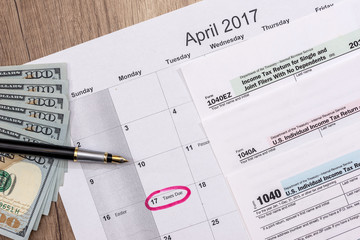 Obraz premium calendar, 2017 tax forms with pen and dollars.