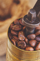 Roasted coffee beans in rustic antique coffee grinder. Copy space