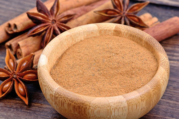 Fototapeta na wymiar Bowl with cinnamon and star anise on table