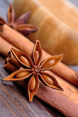 Star anise with cinnamon sticks and bowl on table