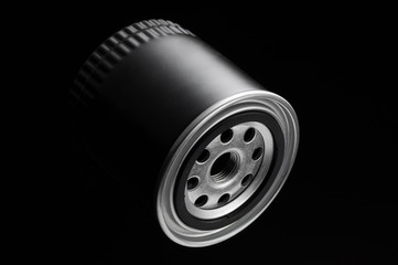 metallic automotive filter cylindrical shape on a black background close up