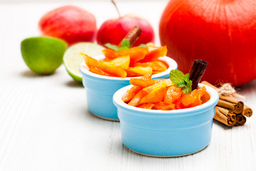 Caramelized  pumpkin and apple in small pot on white