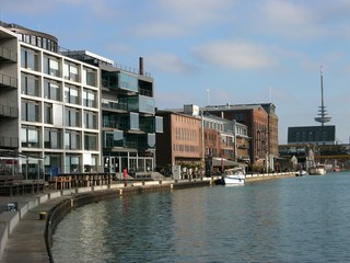 Moderne Bürogebäude und alte sanierte Getreidespeicher und Lagerhäuser bei Sonnenschein am...