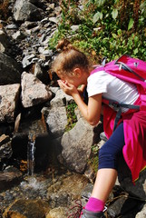 dziewczynaka pije wodę ze strumyka