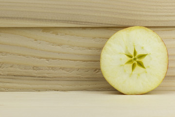 cut fresh juicy natural sour apple half on wooden background