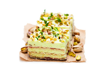Slices  of layered cake with pistachio isolated on white