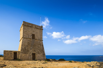 Fototapeta na wymiar Malta - Ghajn Tuffieha watchtower at Golden Bay on a nice sunny summer day with clear blue sky
