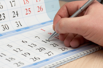 Hand marks date in the calendar