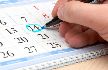 Hand marks date in the calendar in blue