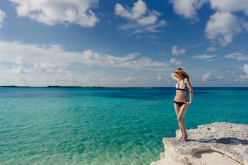 blonde posing on the edge of a cliff Caribbean Sea