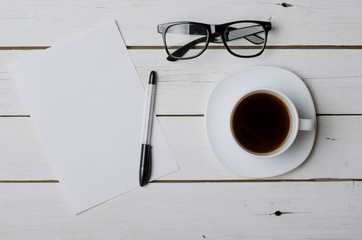 A cup of coffee, glasses and a blank sheet of paper for your tex