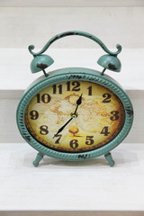 Oval green alarm clock on a wooden background