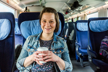 Girl in the train drinking coffee and eating donut