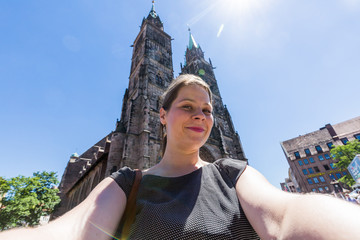 Fototapeta premium Girl is taking selfie in front the Church of Our Lady