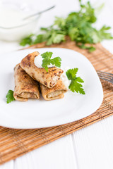 Pancakes filled with meat stuffing on a white plate