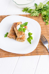 Pancakes filled with meat stuffing on a white plate