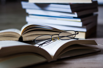 Open book on the table, glasses.