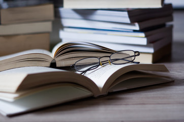 Open book on the table, glasses.