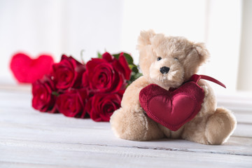 Cute valentine’s teddy bear with red roses, love concept