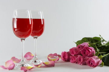 A glass of wine and roses.