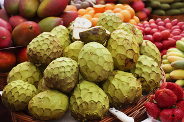 Fototapeta premium Annona fruit and variety of exotic fruit on a street market. Funchal, Madeira, Portugal.