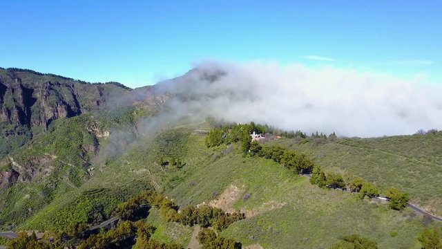 Clouds drifts over lush landscape and volcanic mountains