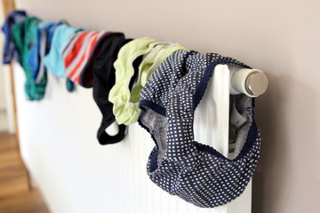 Laundry or washing drying on a domestic radiator - obrazy, fototapety, plakaty