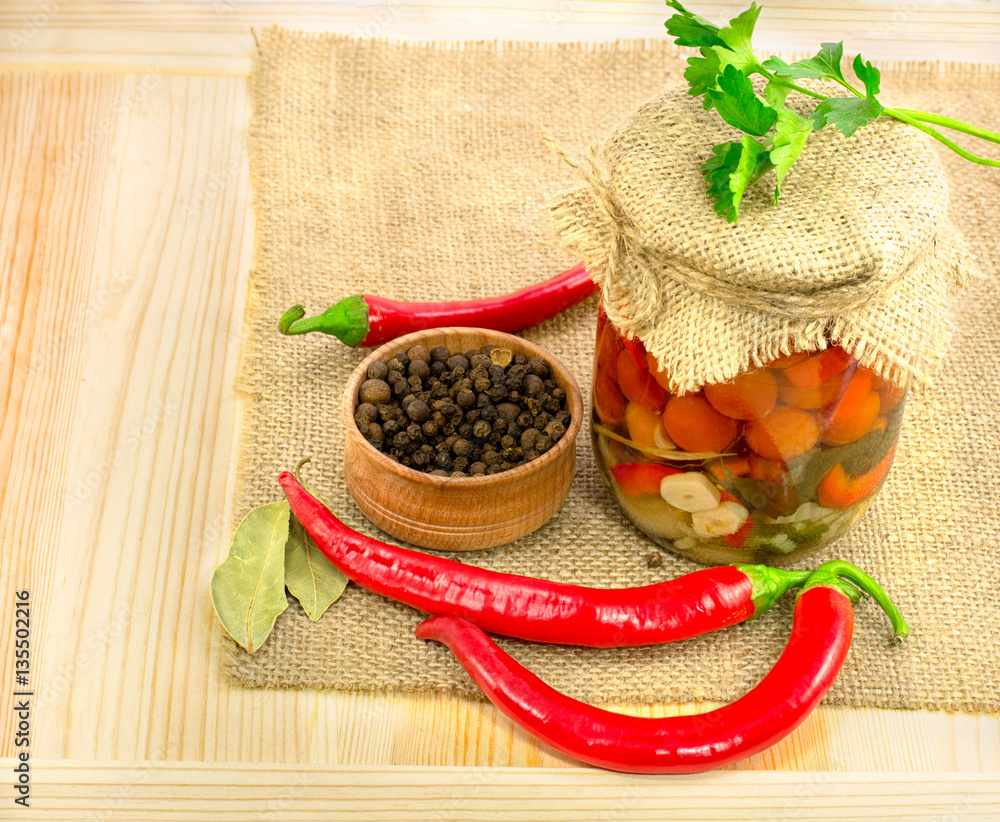 Wall mural canned tomatoes in jar on burlap tablecloths on thin wooden tabl