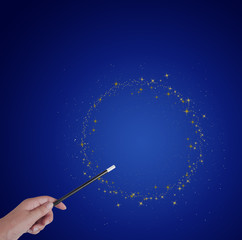 Magic wand in hand, circle or ring of gold stars and stardust on blue.