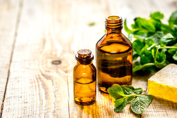 organic cosmetics with herbal extracts of mint on wooden background