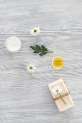 organic cosmetics with camomile on wooden background top view